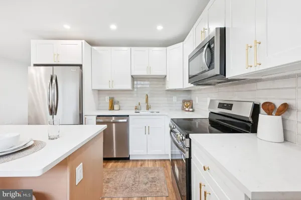 a kitchen with a sink a stove a refrigerator and cabinets