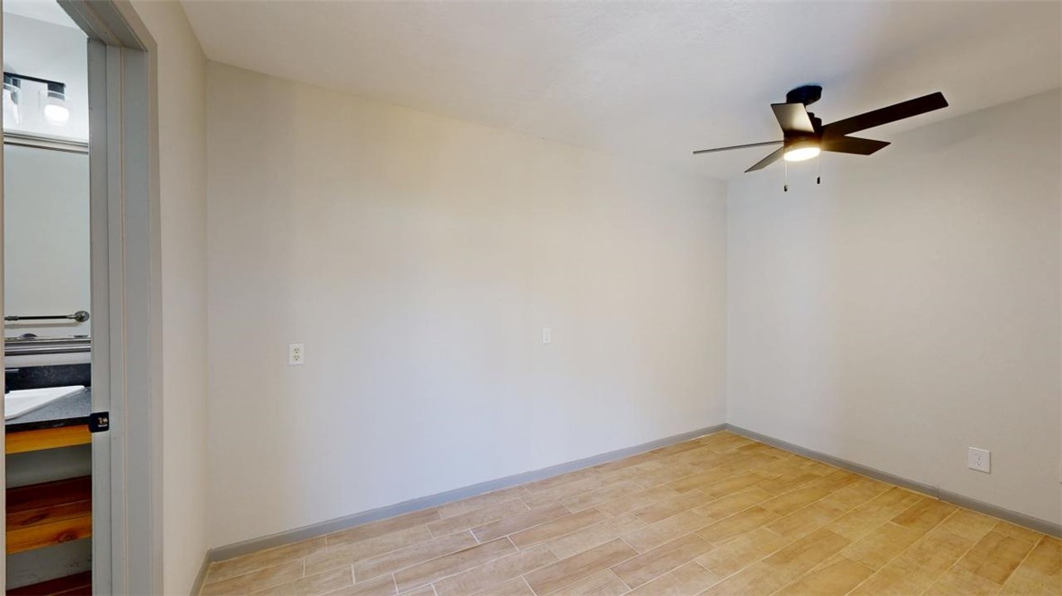 725 Peppertree Drive, Unit 26 Bryan, TX 77801 - Photo 6 of 14 Empty room with baseboards, a ceiling fan, and light wood-style floors