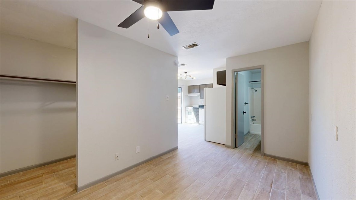 725 Peppertree Drive, Unit 26 Bryan, TX 77801 - Photo 7 of 14 Unfurnished bedroom with ensuite bath, light wood-style flooring, visible vents, and freestanding refrigerator