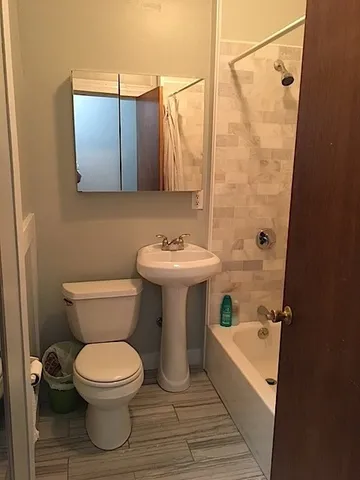 a bathroom with a sink toilet and shower
