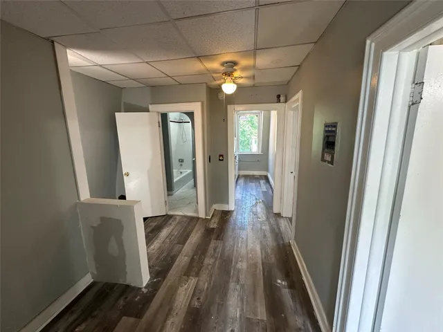 a view of a hallway with wooden floor and staircase