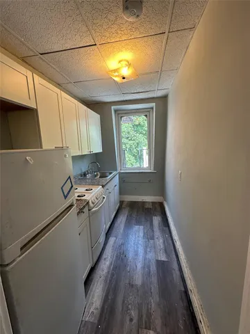 a kitchen with a sink and wooden floor