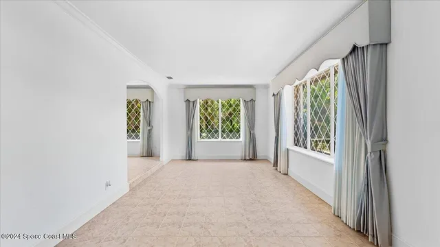 a view of an empty room with window cabinet and fire place