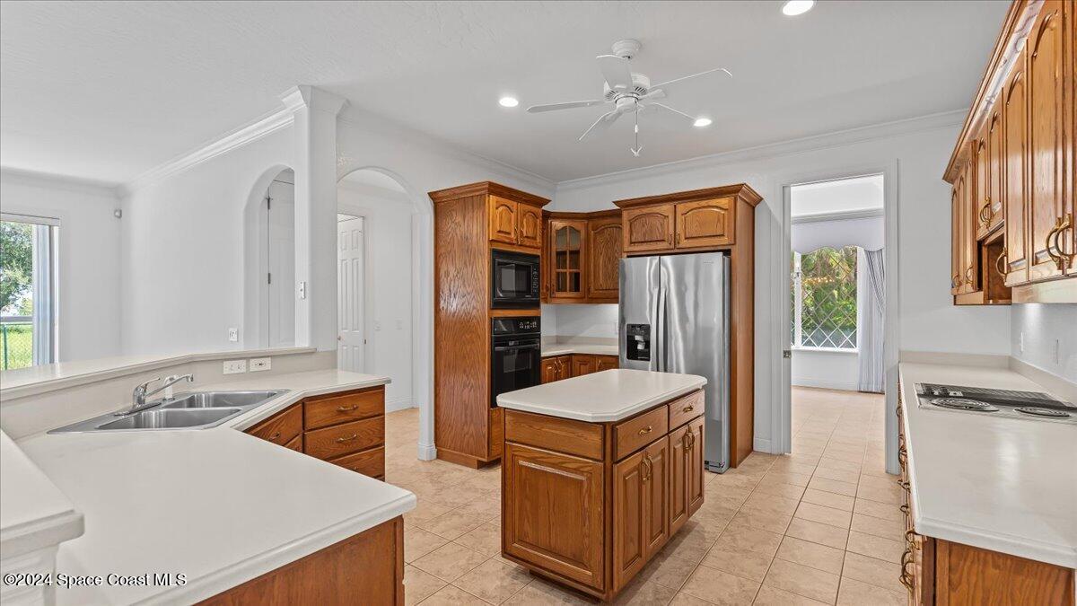 9140 South Tropical Trail Merritt Island, FL 32952 - Photo 27 of 68 a large kitchen with a sink a counter top space stainless steel appliances and a window