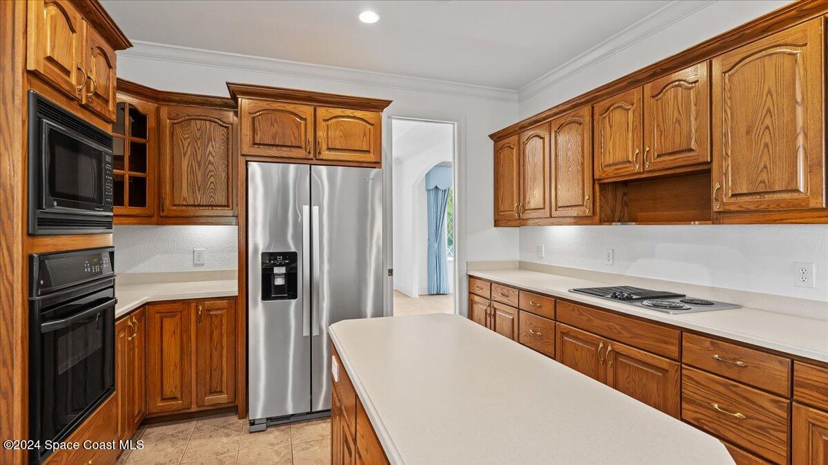 9140 South Tropical Trail Merritt Island, FL 32952 - Photo 30 of 68 a kitchen with stainless steel appliances granite countertop a refrigerator and a stove top oven