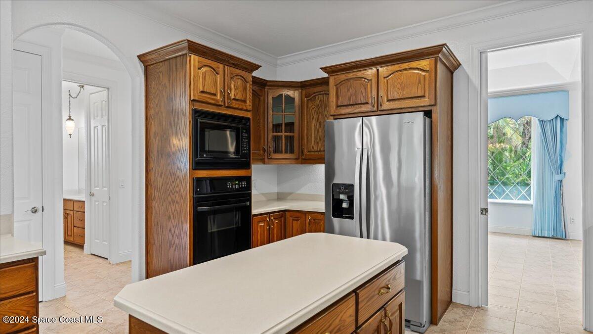 9140 South Tropical Trail Merritt Island, FL 32952 - Photo 31 of 68 a kitchen with stainless steel appliances a refrigerator and a stove top oven