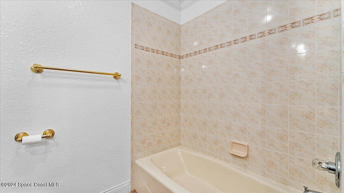 9140 South Tropical Trail Merritt Island, FL 32952 - Photo 34 of 68 a bathroom with a shower and a bath tub