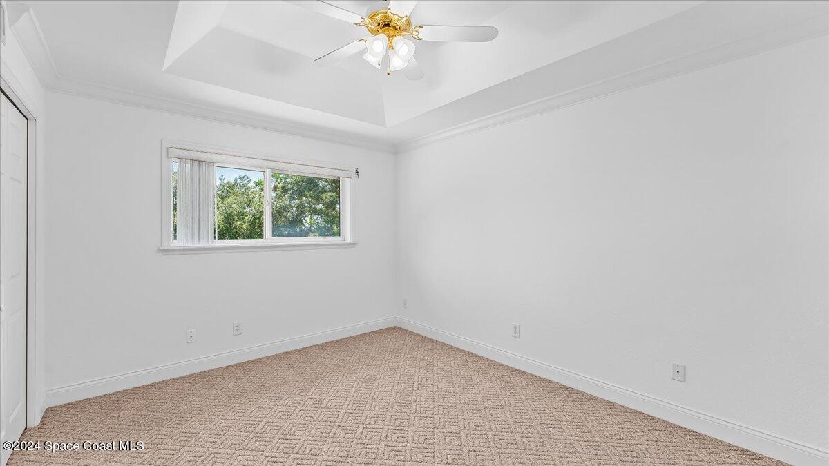 9140 South Tropical Trail Merritt Island, FL 32952 - Photo 35 of 68 an empty room with a window and a chandelier fan