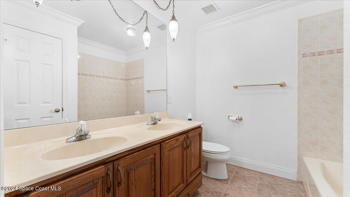 9140 South Tropical Trail Merritt Island, FL 32952 - Photo 40 of 68 a bathroom with a sink a toilet and a large mirror