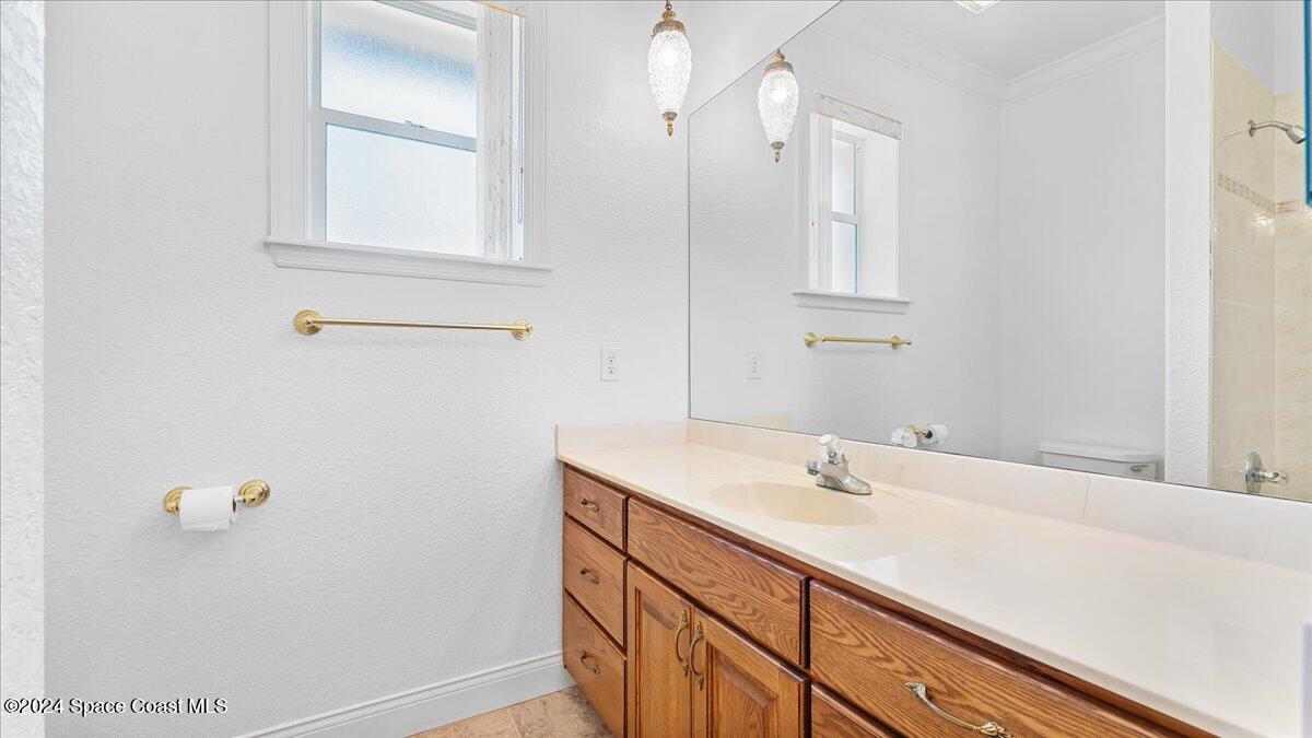 9140 South Tropical Trail Merritt Island, FL 32952 - Photo 50 of 68 a bathroom with a sink a vanity and a mirror