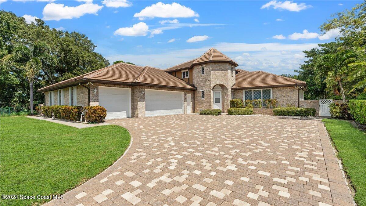 9140 South Tropical Trail Merritt Island, FL 32952 - Photo 60 of 68 a front view of a house with a garden