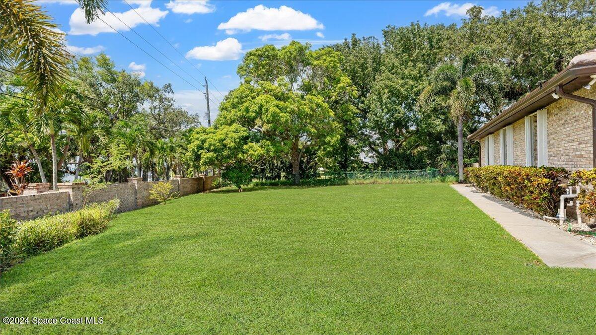 9140 South Tropical Trail Merritt Island, FL 32952 - Photo 7 of 68 a view of a yard with a house in the background