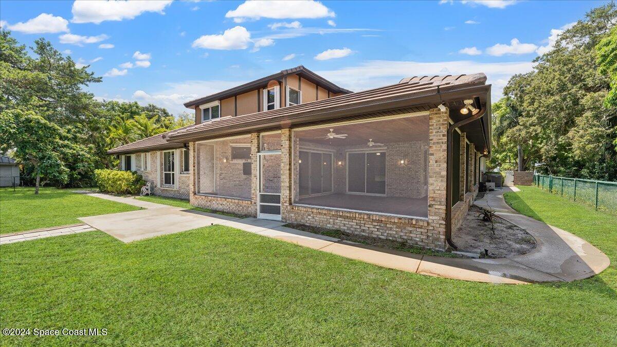 9140 South Tropical Trail Merritt Island, FL 32952 - Photo 9 of 68 a front view of a house with a garden
