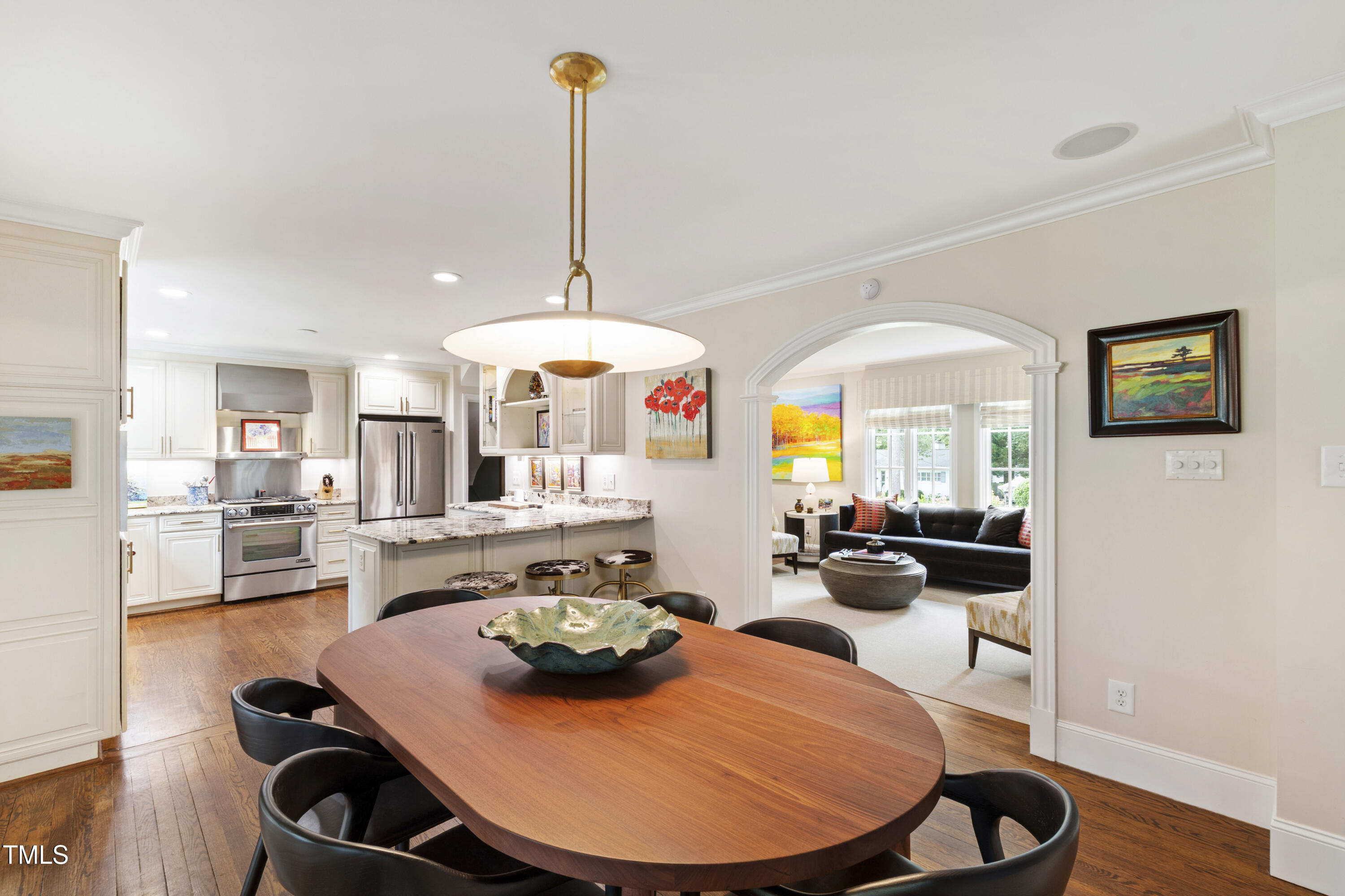 2610 Wells Avenue Raleigh, NC 27608 - Photo 20 of 64 a view of a dining room and livingroom with furniture wooden floor a chandelier