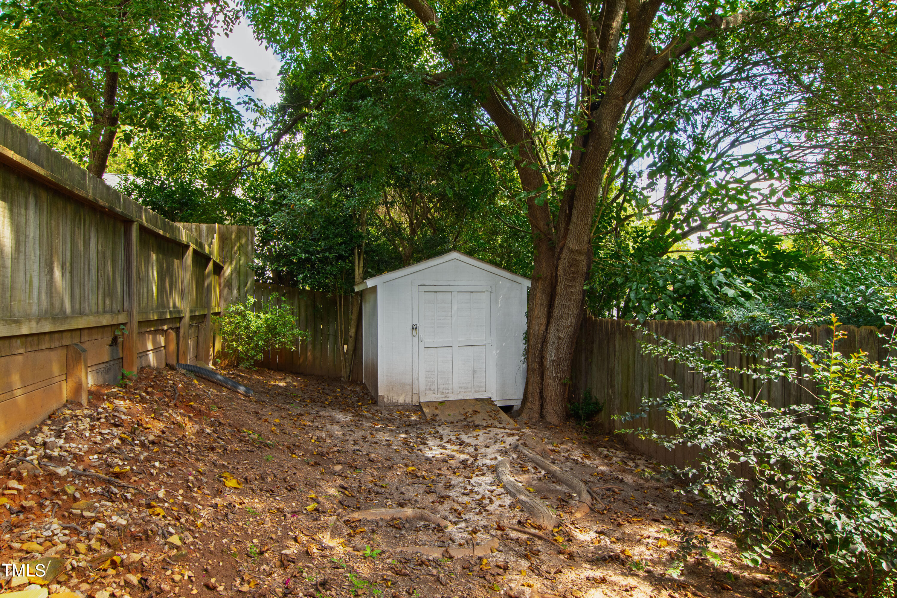 2610 Wells Avenue Raleigh, NC 27608 - Photo 54 of 64 a backyard of a house with a large tree and wooden fence