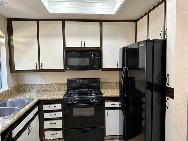 a kitchen with a refrigerator a stove a microwave and cabinets