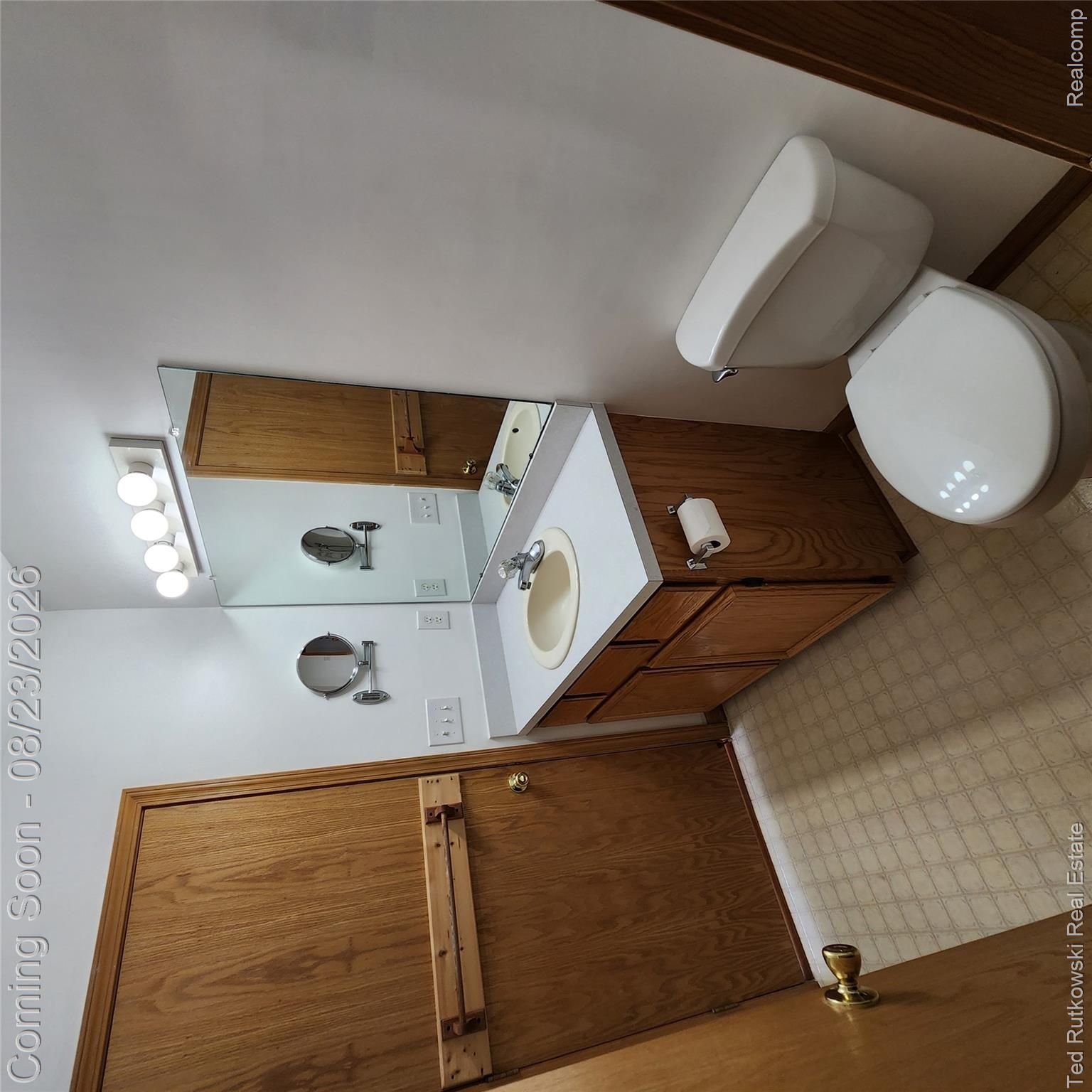 12350 Masters Road Memphis, MI 48041 - Photo 30 of 45 Second bath with double doors accessible from both living & rear garage entrance with Wood-finish vanity, countertop, integrated sink, wall-mounted mirror.