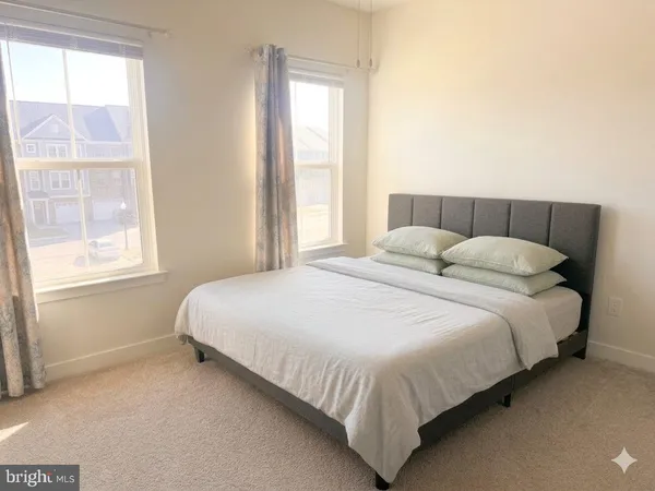 a large bed sitting in a bedroom next to a window