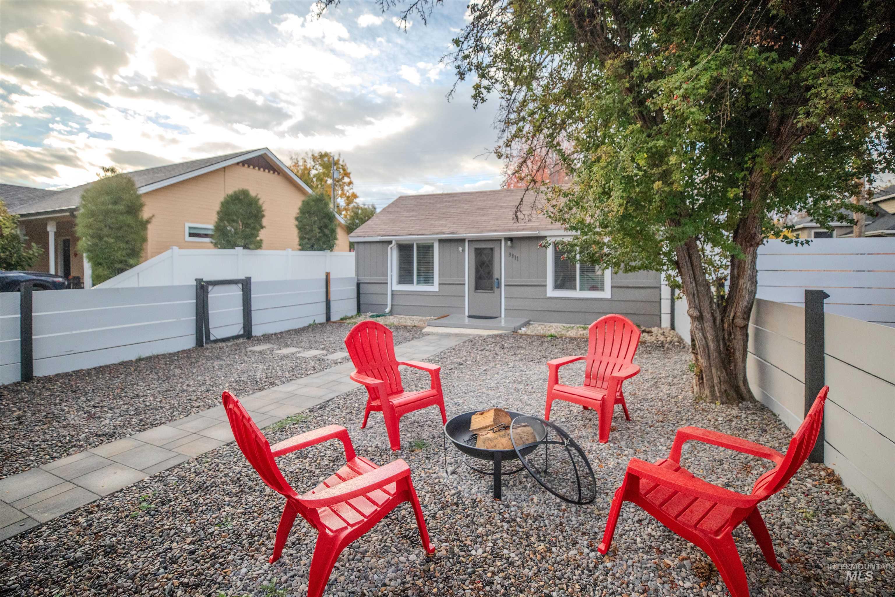 3311 Hamilton Street Boise, ID 83705 - Photo 5 of 31 View of house with a fenced yard, a fire pit, and a shingled roof