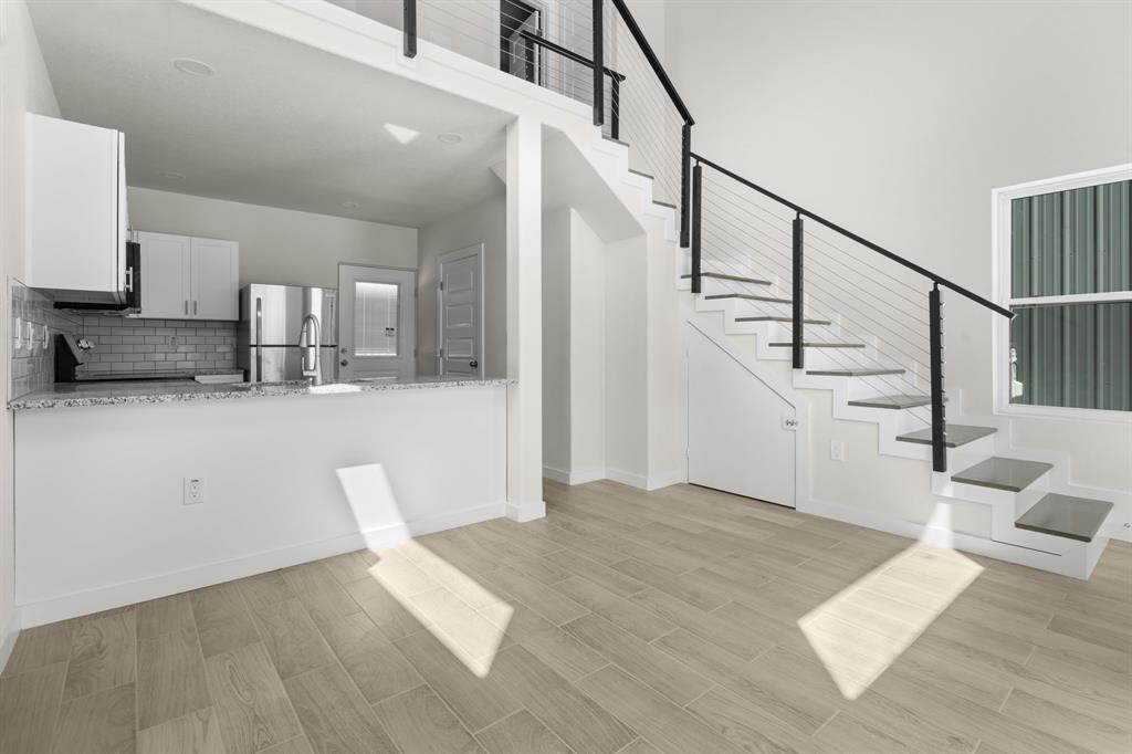 802 Old Wise Road, Unit 23 Bowie, TX 76230 - Photo 3 of 22 a view of a livingroom with wooden floor and stairs