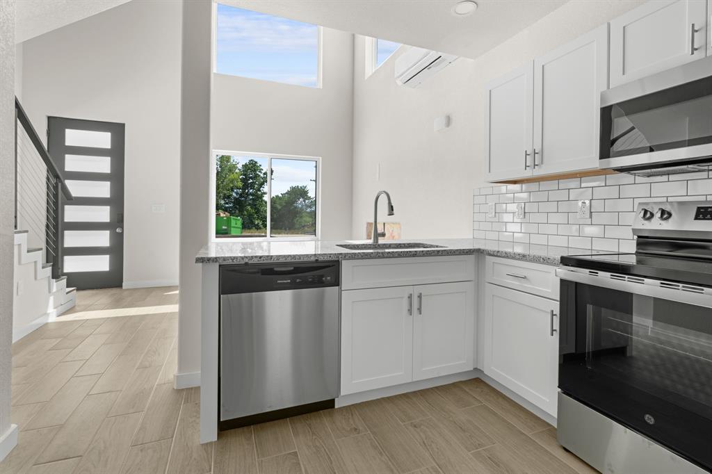 802 Old Wise Road, Unit 23 Bowie, TX 76230 - Photo 6 of 22 a kitchen with stainless steel appliances granite countertop a sink a stove and a microwave