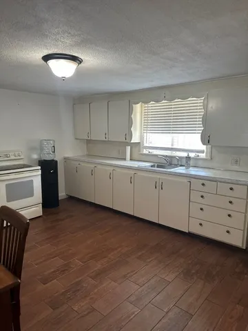 a kitchen with granite countertop white cabinets and white appliances