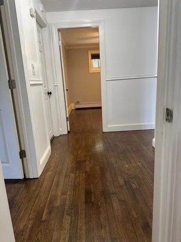 a view of a room with wooden floor and white walls