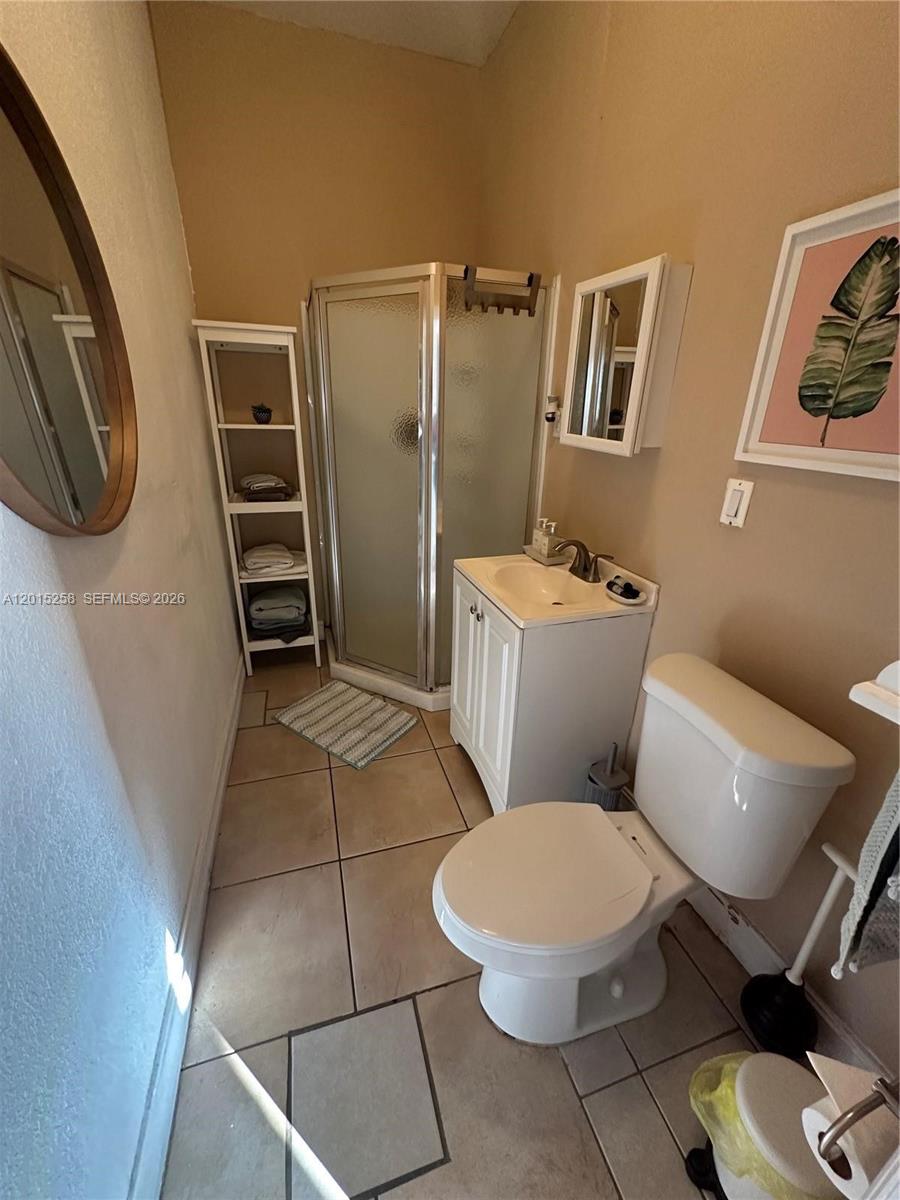 1678 Southwest 11th Street, Unit STUDIO Miami, FL 33135 - Photo 8 of 9 a white toilet sitting next to a bathroom sink and a mirror
