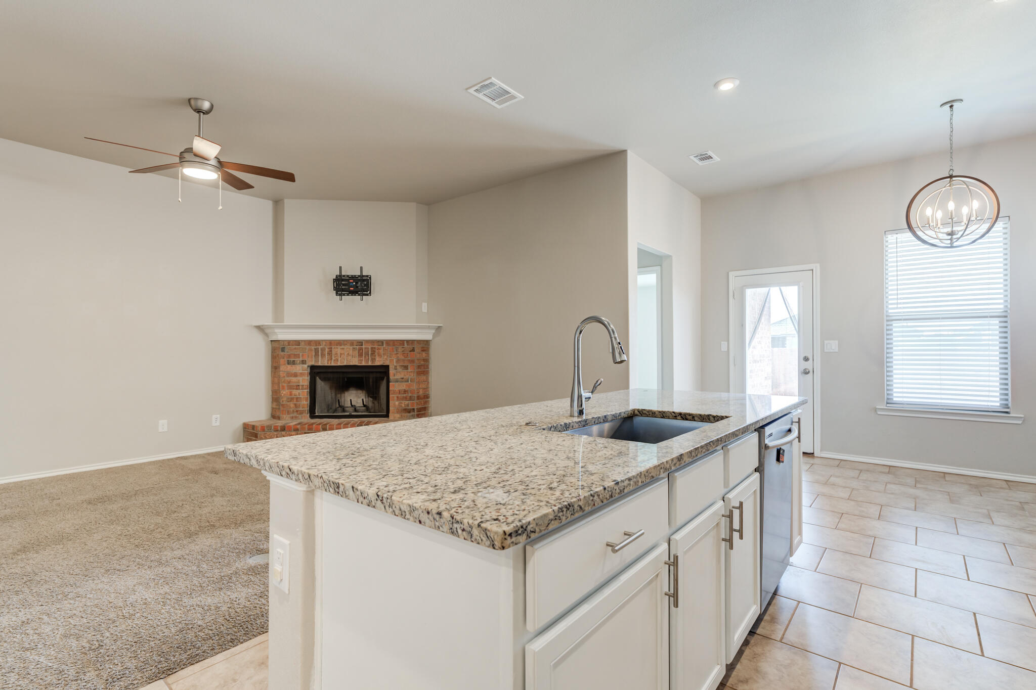 7519 101st Street Lubbock, TX 79424 - Photo 12 of 44 a kitchen with granite countertop a sink and a fireplace