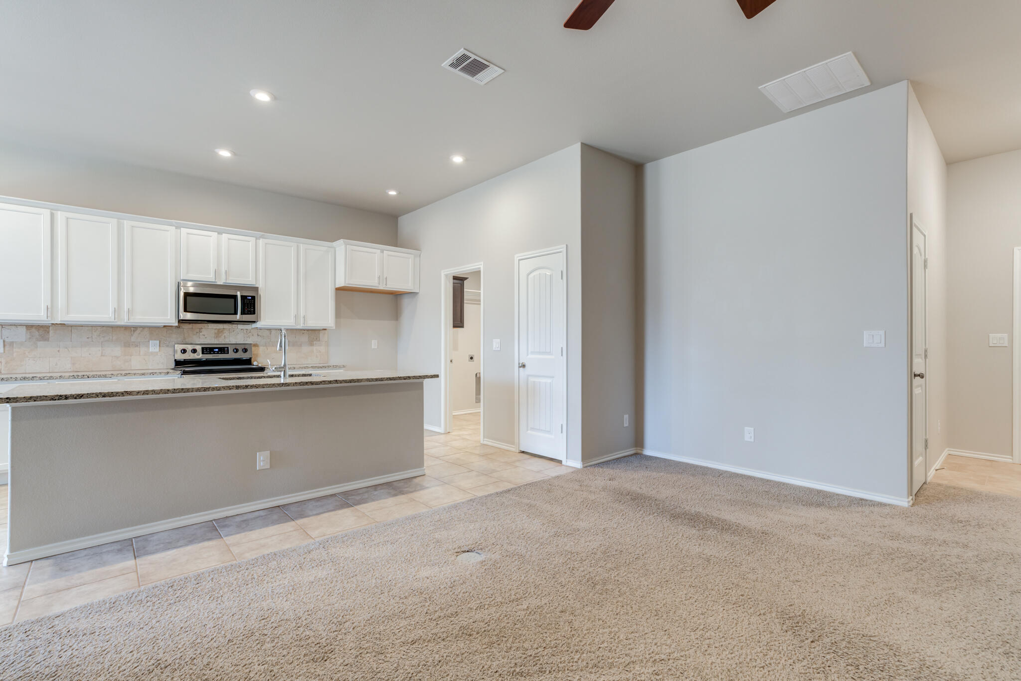 7519 101st Street Lubbock, TX 79424 - Photo 24 of 44 a kitchen with granite countertop white cabinets and stainless steel appliances