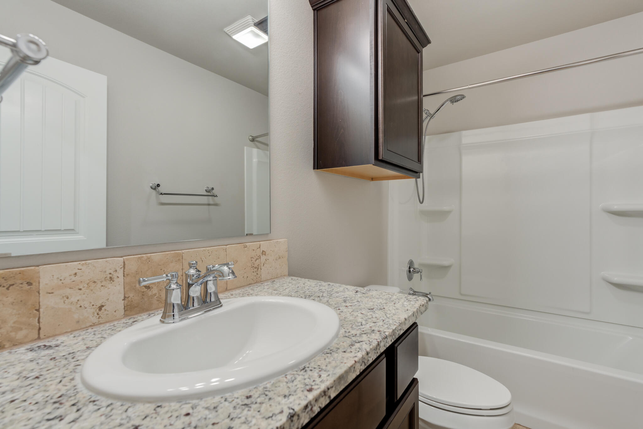 7519 101st Street Lubbock, TX 79424 - Photo 38 of 44 a bathroom with a granite countertop sink and a mirror