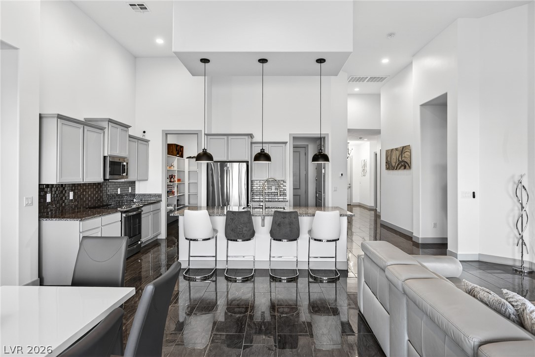 1460 Blue Ridge Trail Mesquite, NV 89027 - Photo 7 of 39 Culinary delights await in this modern kitchen with an inviting island and overhead pendant lighting.