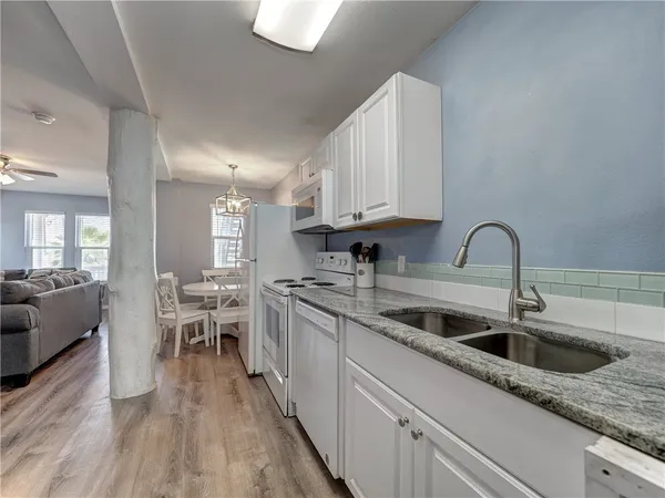 a kitchen with stainless steel appliances granite countertop a sink a stove and cabinets