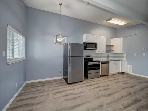 a kitchen with a refrigerator and a stove top oven