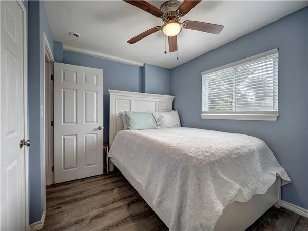 a bedroom with a large bed and a chandelier
