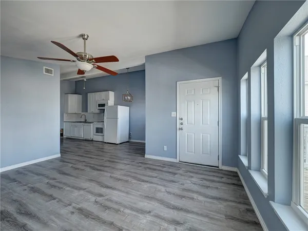 a view of a kitchen with wooden floor and a ceiling fan