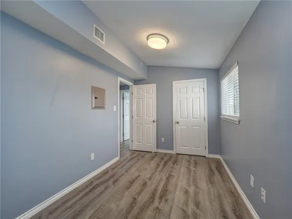 a view of a room with wooden floor and windows