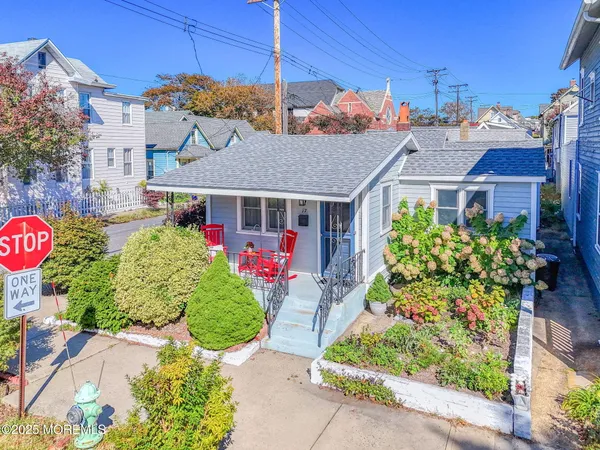 a front view of a house with a yard and potted plants