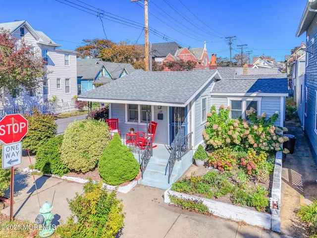 a front view of a house with a yard and potted plants