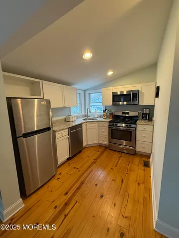 a kitchen with stainless steel appliances granite countertop a refrigerator and a stove top oven