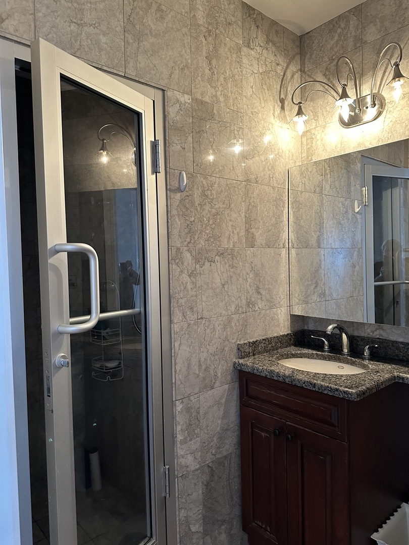 860 North Lake Shore Drive, Unit 5M Chicago, IL 60611 - Photo 11 of 11 a bathroom with a sink and mirror