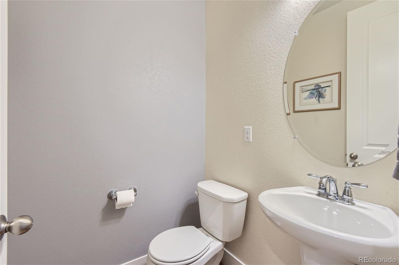 10495 Rutledge Street Parker, CO 80134 - Photo 12 of 32 a bathroom with a toilet a sink and mirror