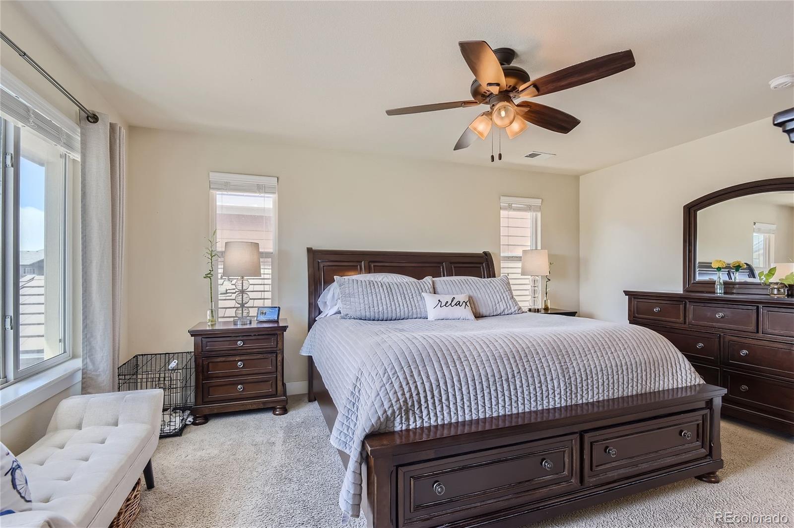 10495 Rutledge Street Parker, CO 80134 - Photo 14 of 32 a bedroom with a bed a dresser and a chandelier