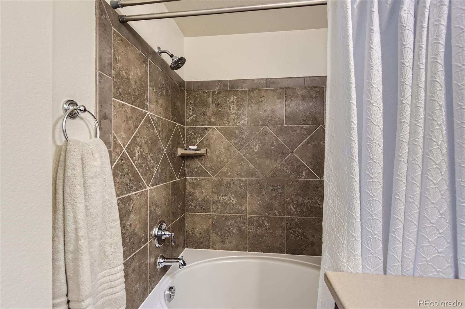 10495 Rutledge Street Parker, CO 80134 - Photo 17 of 32 a bathroom with a bathtub and shower