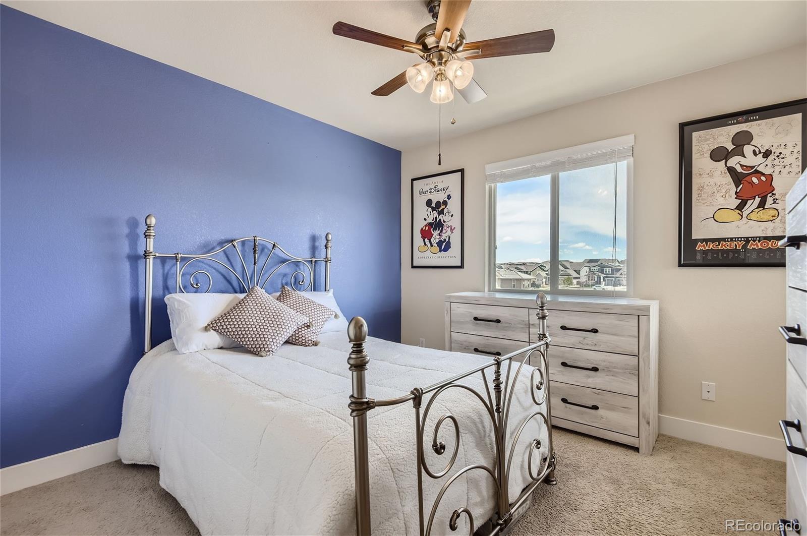 10495 Rutledge Street Parker, CO 80134 - Photo 18 of 32 a bedroom with a bed and a chandelier