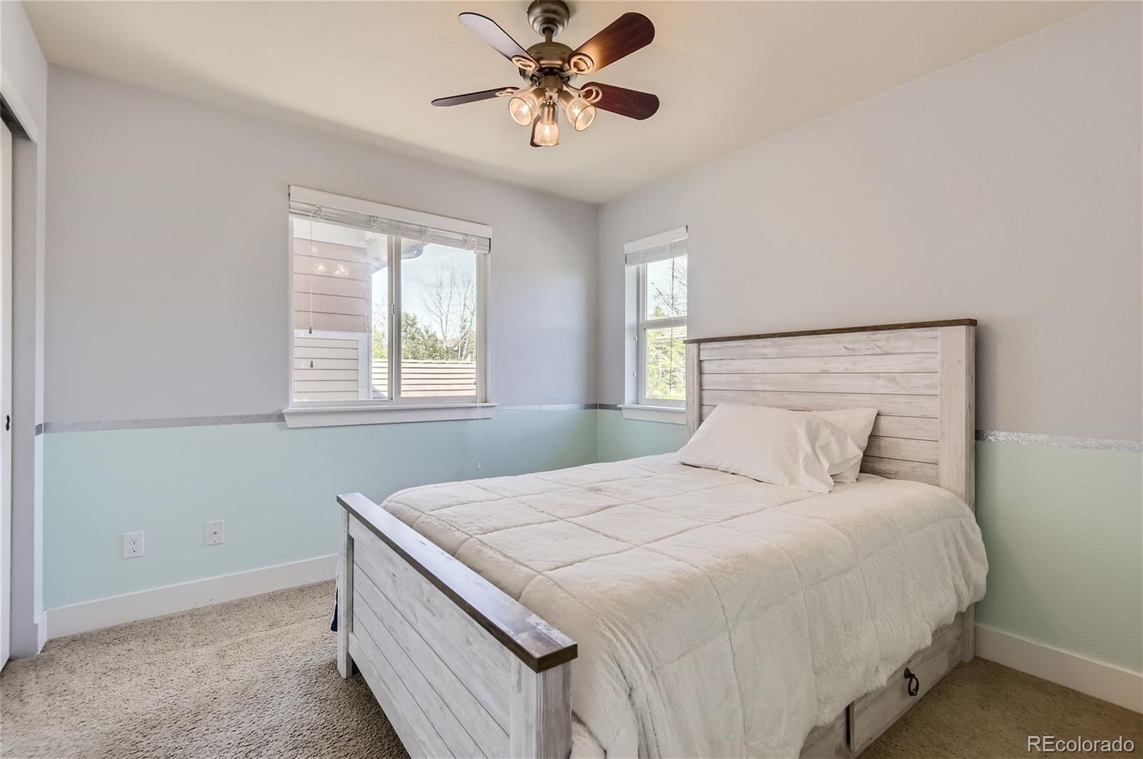 10495 Rutledge Street Parker, CO 80134 - Photo 22 of 32 a bedroom with a bed and a chandelier