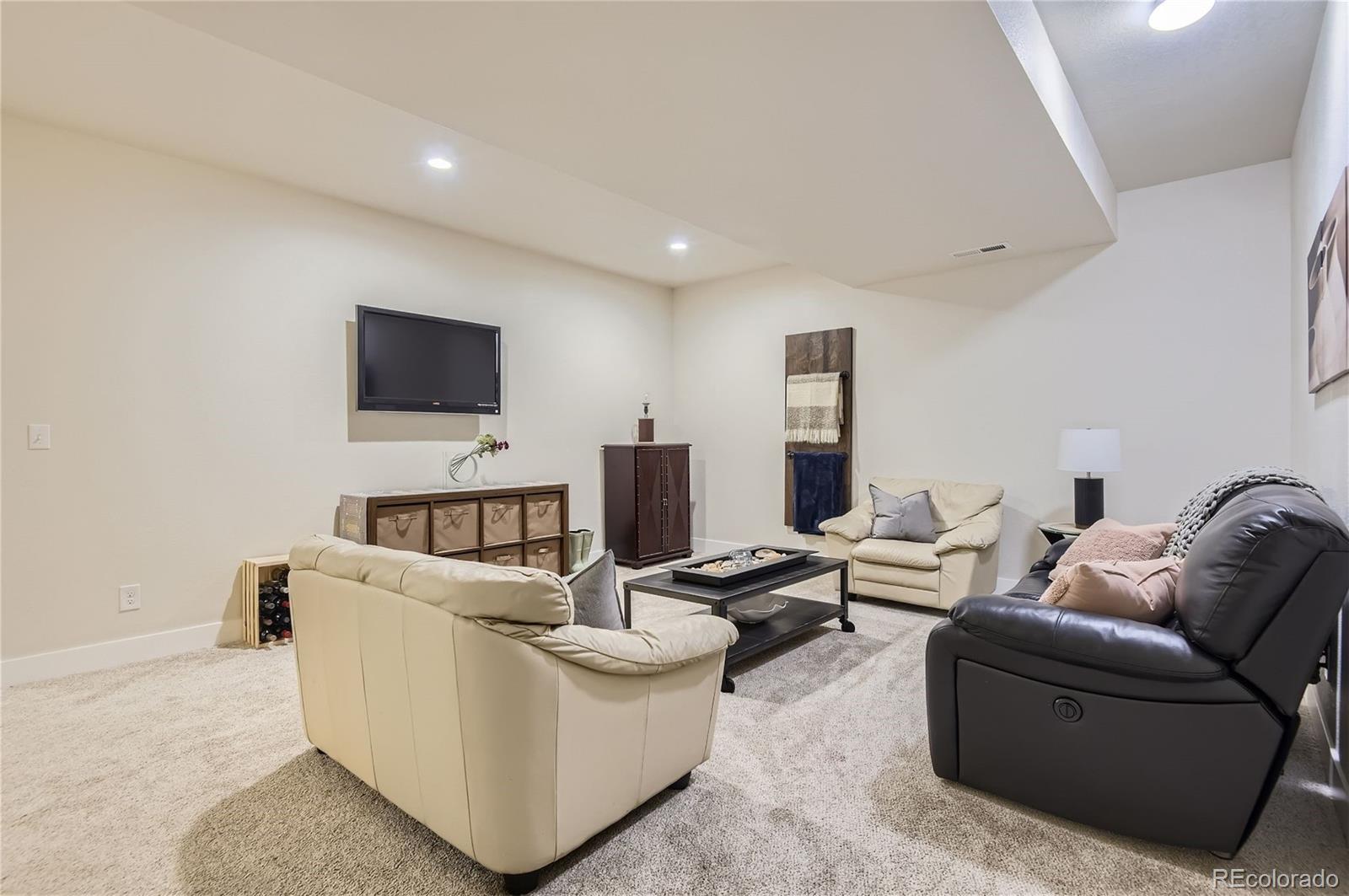 10495 Rutledge Street Parker, CO 80134 - Photo 23 of 32 a living room with furniture and a flat screen tv