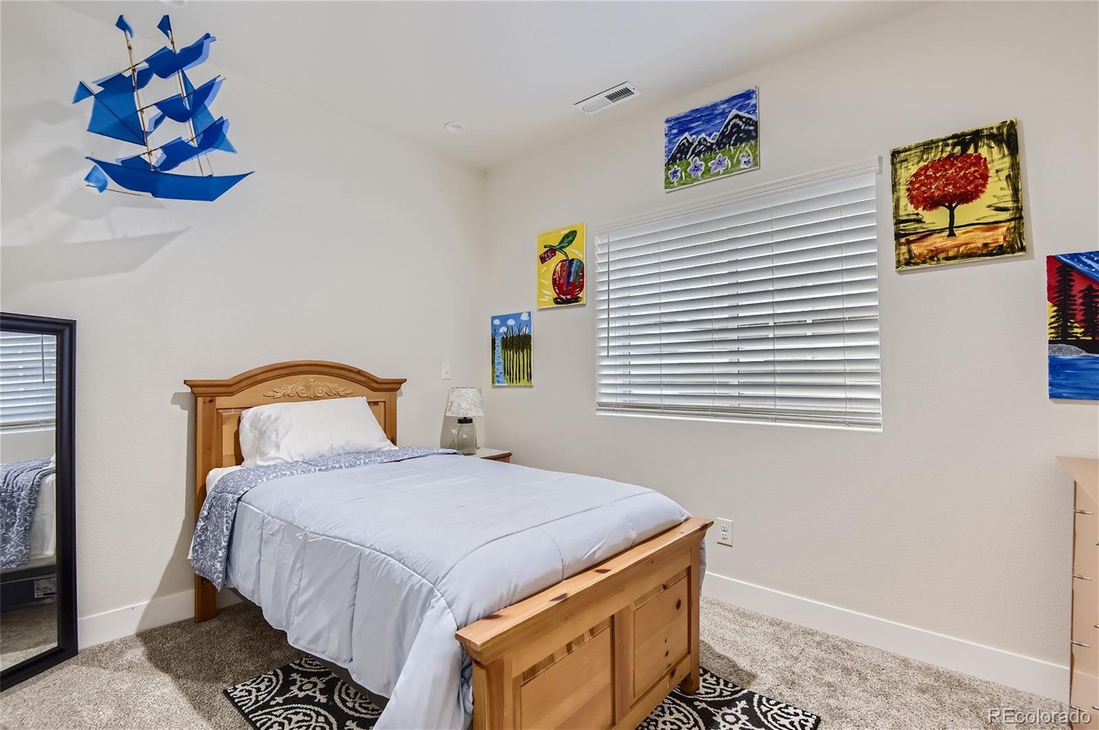 10495 Rutledge Street Parker, CO 80134 - Photo 25 of 32 a bedroom with a bed and a painting on the wall