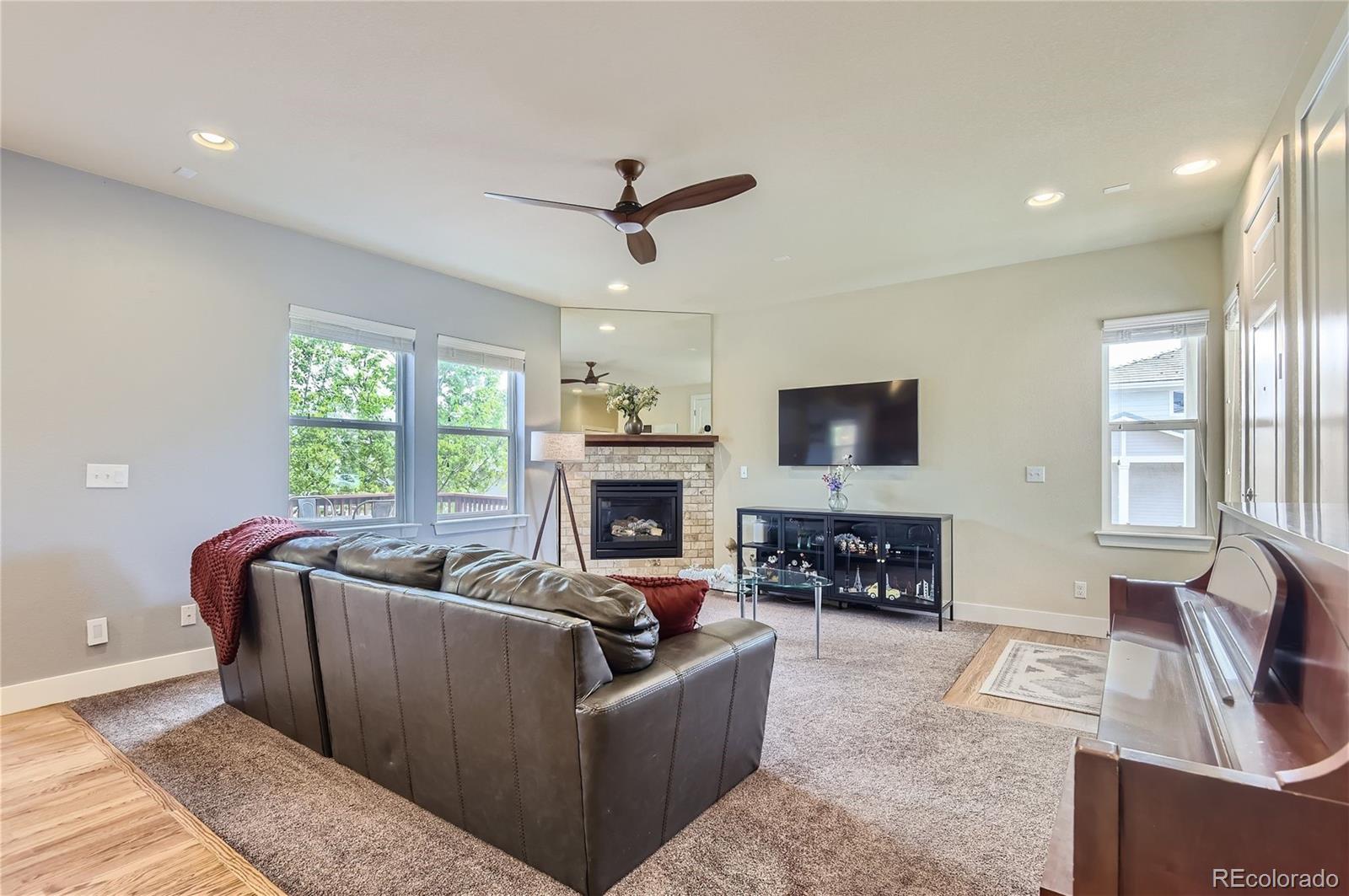 10495 Rutledge Street Parker, CO 80134 - Photo 5 of 32 a living room with furniture flat screen tv and a fireplace