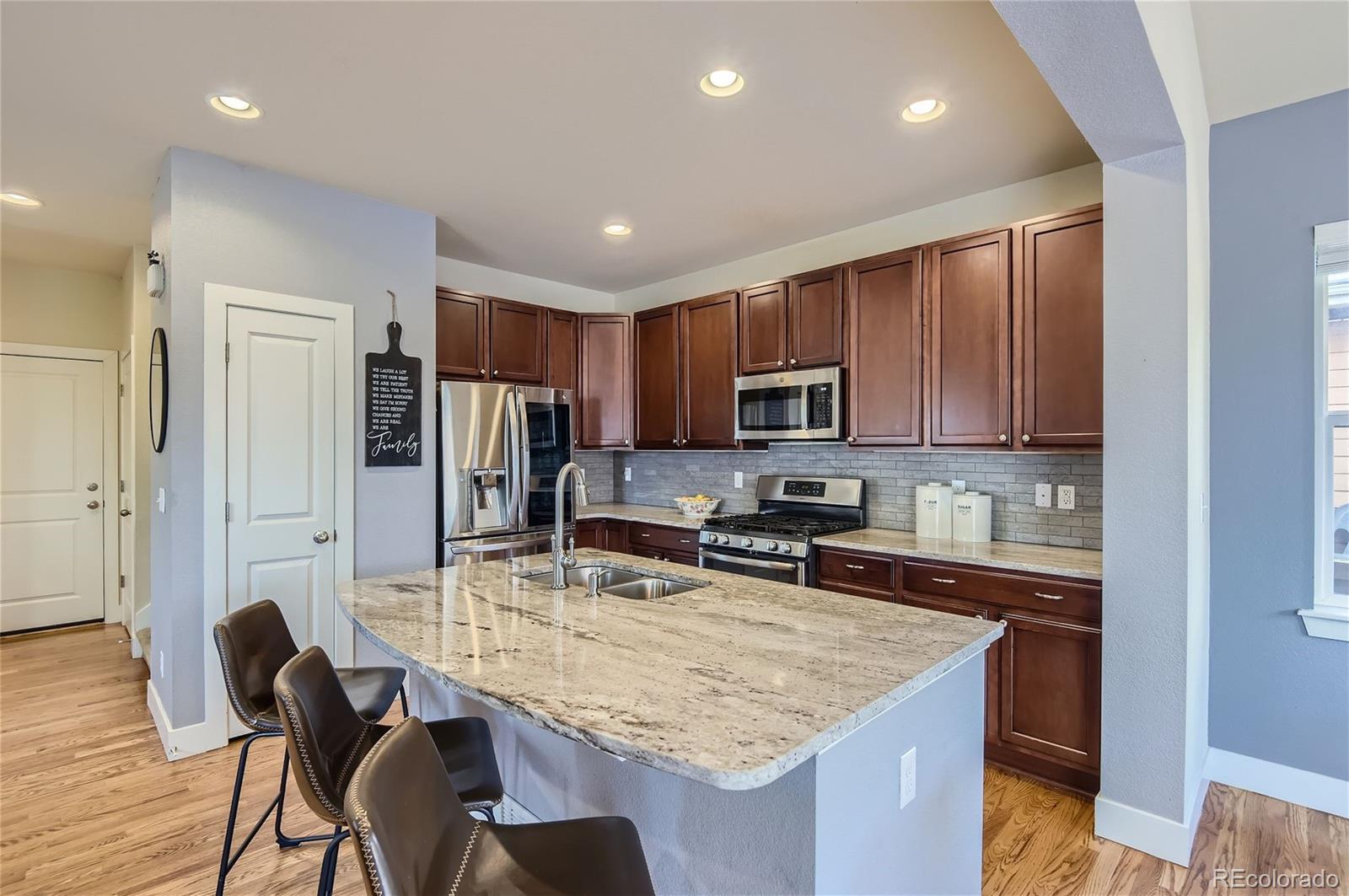 10495 Rutledge Street Parker, CO 80134 - Photo 8 of 32 a kitchen with stainless steel appliances granite countertop a sink refrigerator and cabinets